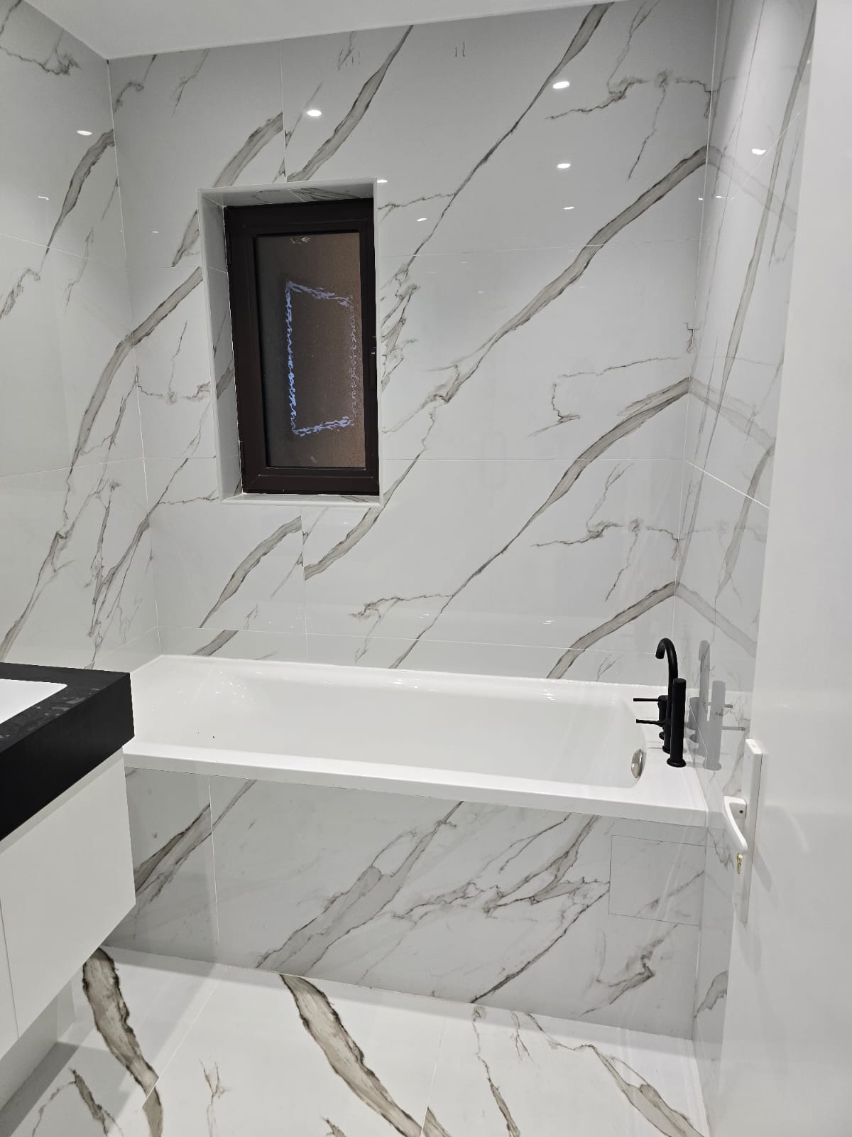 Marble-clad bathtub recess — Business Bay apartment