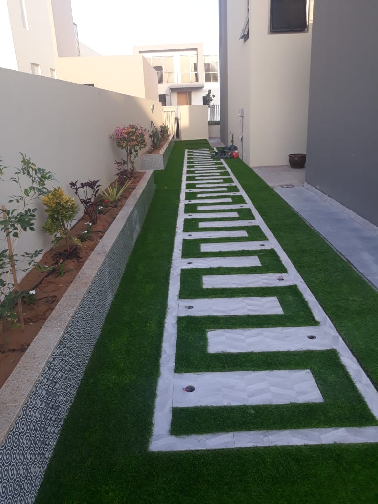 Geometric lawn and stone steppers — Damac Hills side yard